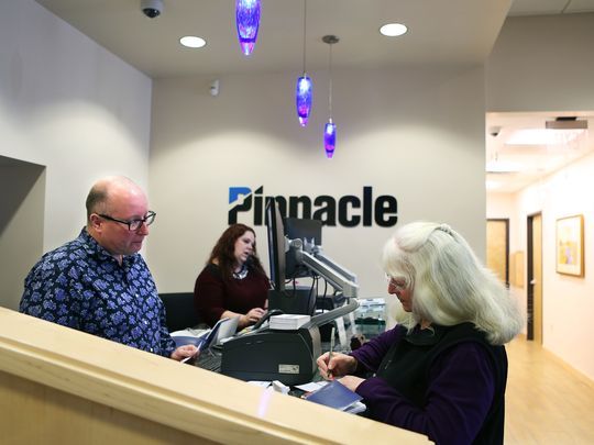 Pinnacle Financial Partners service specialist Johnny Thompson assists customer Gail Zacharias during a transaction in Germantown on Wednesday morning. (Photo: Yalonda M. James/The Commercial Appeal)